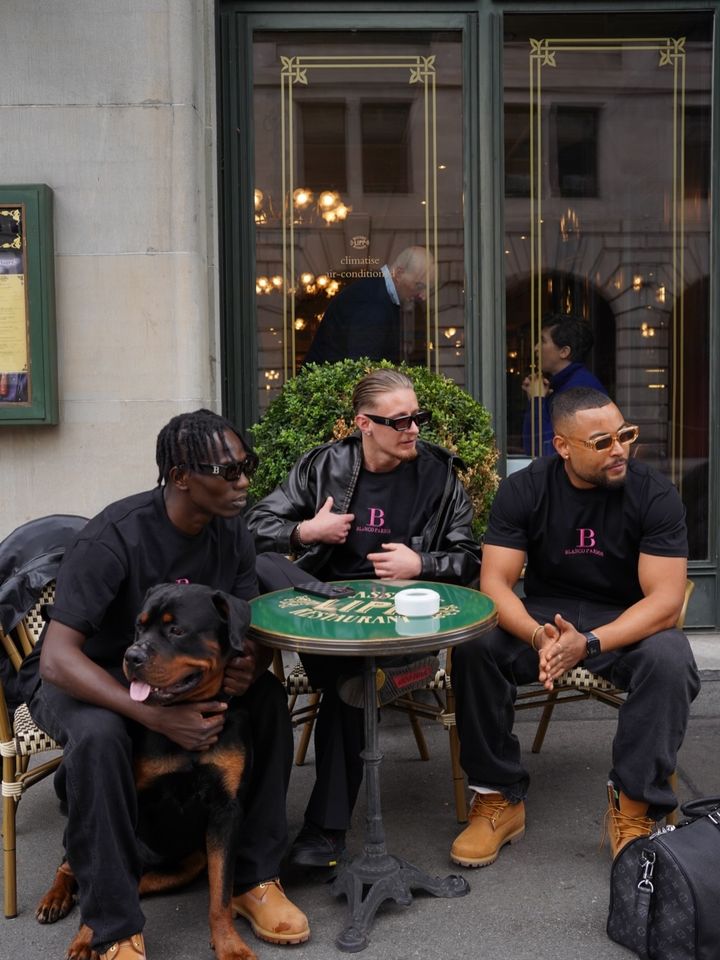 BLANCO PARDON crew with a Rottweiler at a cafe table